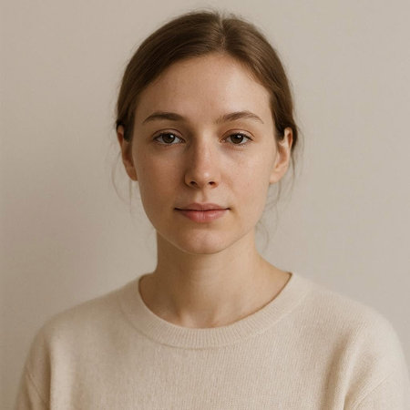 Portrait of a young girl in a beige sweater on a gray backgroundの写真素材