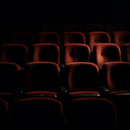 Cinema auditorium with red seats and lighting in the darkの写真素材