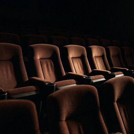 Empty cinema auditorium with rows of brown leather seats. Backlight.