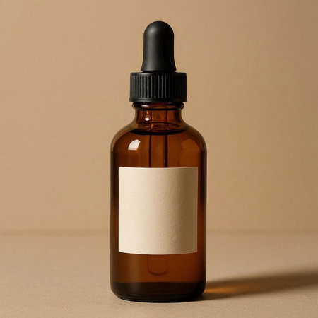 Brown glass dropper bottle with blank label on beige background.