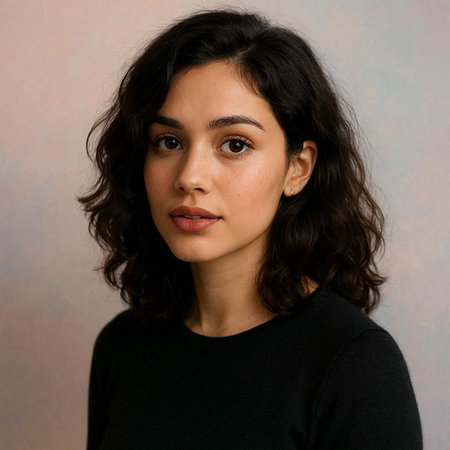 Portrait of a beautiful young woman with long curly hair against a plain background