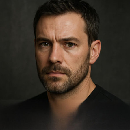 Portrait of a man with a beard on a dark background.