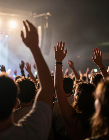 Concert crowd at a music festival, hands raised in the air