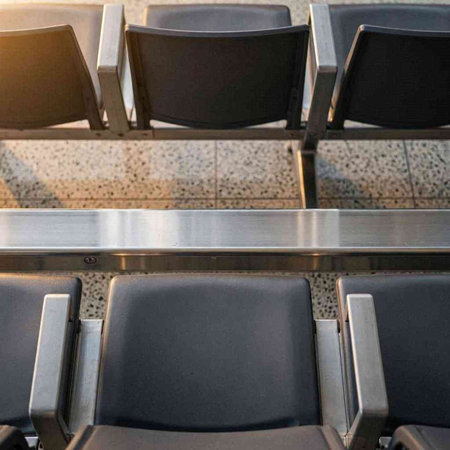 Empty chairs in a row in an airport, waiting for departure.