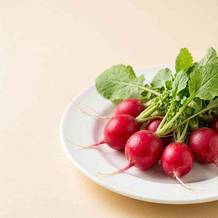 Fresh radishes on a white plate on a beige background.