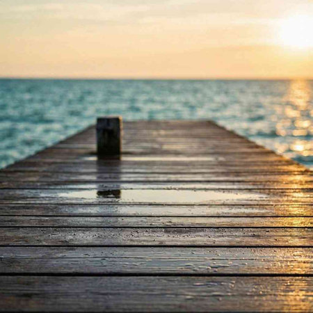 Wooden jetty at sunset with water drops on the surface.