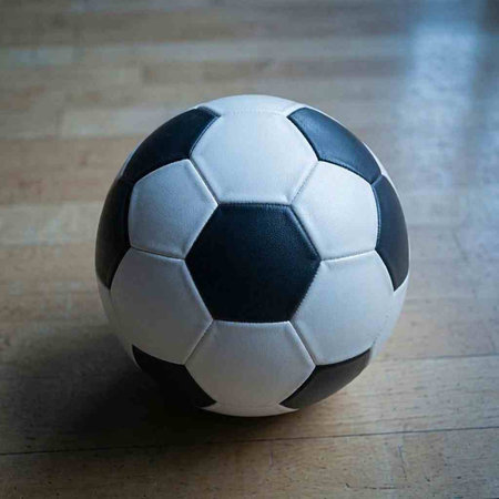 Black and white soccer ball on wooden floor. Soccer ball on wooden floor