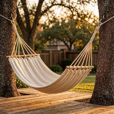 Hammock on the wooden deck in the garden with tree.