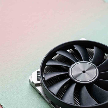 Close up of a computer fan on a green background with copy space