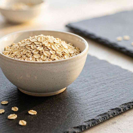 Oat flakes in a ceramic bowl on a slate plate. Selective focus.