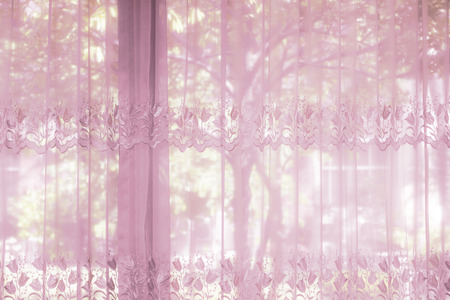 A bedroom windows dressed with striped curtain that lace drapery pattern with flower shapeの写真素材
