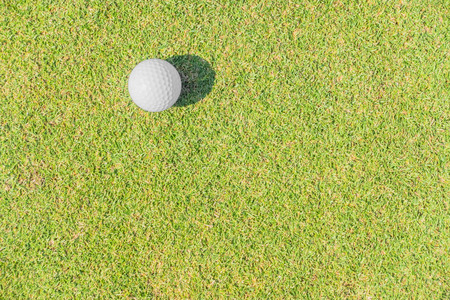A golf ball against grass background.の写真素材