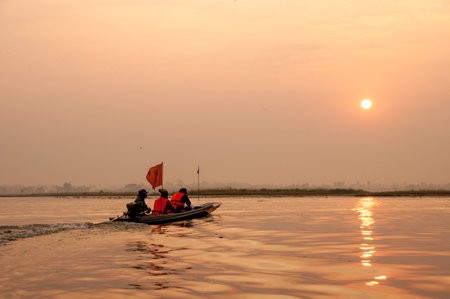 people in long-tailed boat in lake at sunriseの写真素材