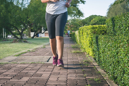 Young female jogging in park at morning