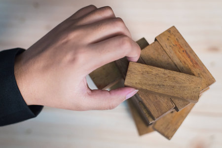 Planning, risk and strategy in business, businessman gambling placing wooden block on a towerの写真素材