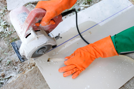 Man with grinder cutting a granito tileの写真素材