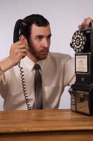 Young businessman dealing with too many phonesの写真素材