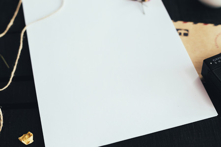 Cozy blank a4 sheet mockup, Blank paper with artist brushes on wooden table with cup and cameraの写真素材