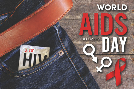 world aids day condom injeans back pocket with wooden table background, vintage toneの写真素材