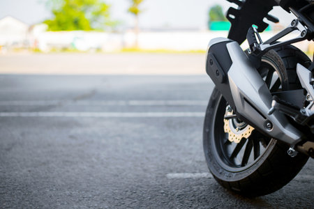 closeup tire and exhaust pipe of  sport motorcycle with soft-focus and over light in the backgroundの写真素材