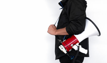 young man holding megaphone on white brick wall backgroundの写真素材
