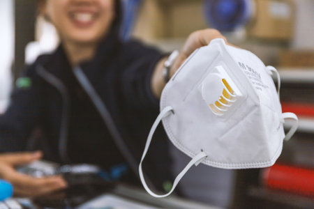 closeup N95 air filter mask. personal protective equipment on the hands of women with soft-focus and...