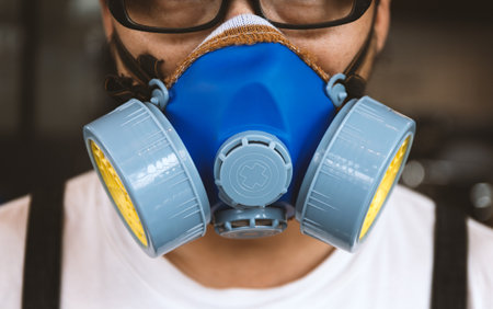 closeup men wearing respirator mask industrial cartridge filter anti-dust safety chemical with soft-focus and over light in the backgroundの写真素材