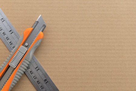 cutter knives and steel ruler on paper crates background. top viewの写真素材