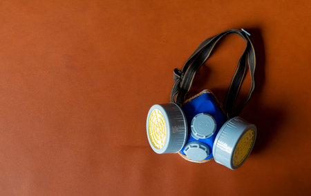 respirator mask industrial cartridge filter anti-dust safety chemical on red leather floor background. top viewの写真素材