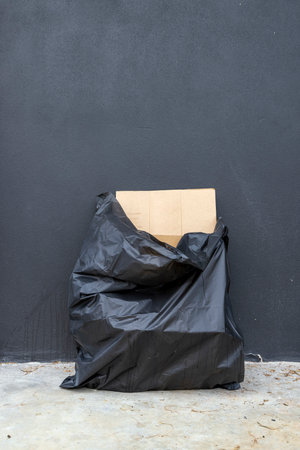 black garbage bag with old brick wall backgroundの写真素材