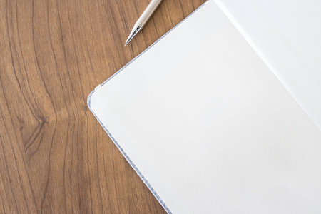 top view of blank open notebook page and pencil on wood table background in office.