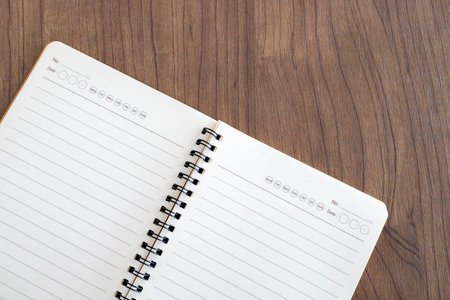 top view of blank open notebook page and pencil on wood table background in office. space for text....