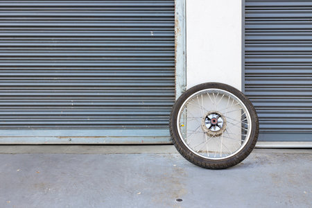 motorcycle tire placed in front of the garage door. space for textの写真素材