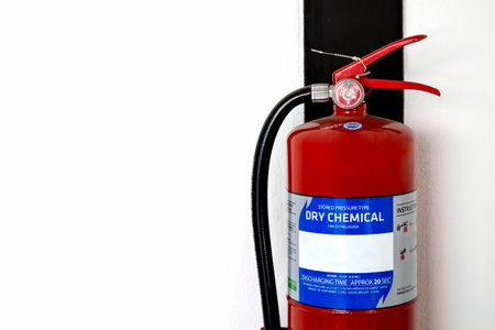 closeup red fire extinguisher with soft-focus and over light in the backgroundの写真素材