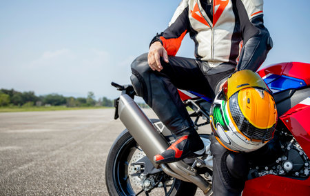 rider motorbike holding his motorcycle helmet sitting on a big bike in the road riding with...
