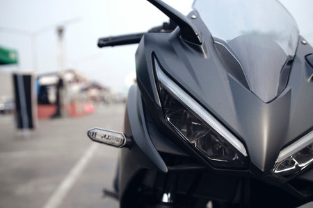 closeup headlight front view of motorcycle bigbike in showroom with soft-focus and over light in the...