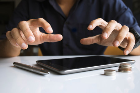 businessman working in the office. he is using touchpad reading an email on tablet and taking notes...