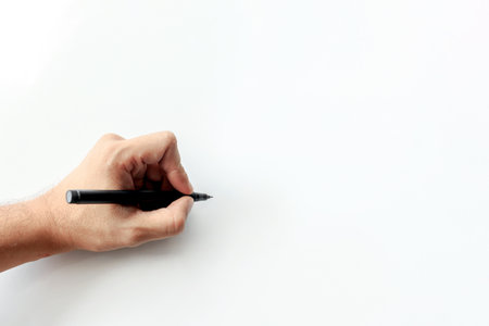 man's hand holding a pen writing on white background. space for textの写真素材
