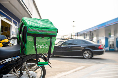 Chiang Rai, Thailand - April 1, 2021 closeup bag grab food motorbike at the street. food delivery service through its mobile application. soft-focsu and over light in the backgroundのeditorial素材