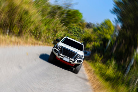 car on the mountain road with blur, soft-focus and over light in the background. white pickup truck 4x4 driving on highway in the forest with mountain.の写真素材