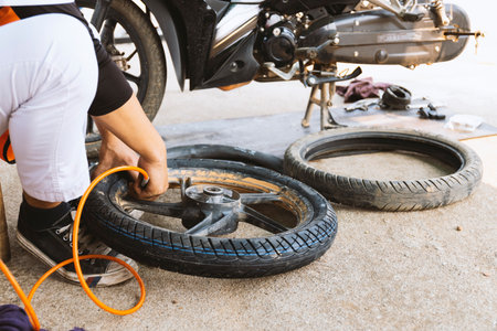 Service worker changing motorcycle tire installation in the workshop for motorcycle repairment with...