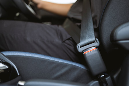 Close-up Men's hand fastens the seat belt of the car while sitting inside the car before driving and...