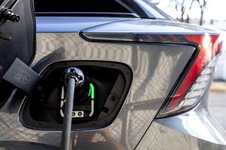 Close-up of an electric vehicle plugged in at a charging station, showcasing sustainable and eco-friendly transportation.の写真素材