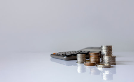 Stacked coins with percentage growth arrows and a calculator, symbolizing increasing interest rates, financial growth, and investment opportunities.の写真素材