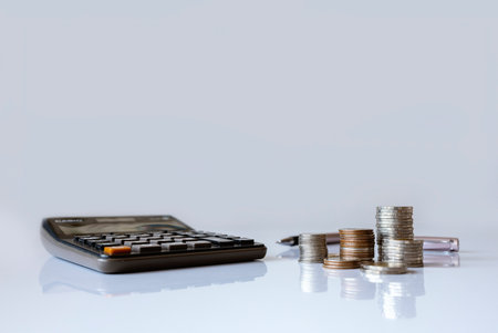 Stacked coins with percentage growth arrows and a calculator, symbolizing increasing interest rates, financial growth, and investment opportunities.の写真素材