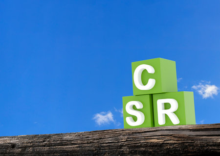 Green CSR text with a recycling symbol against a blue sky, symbolizing sustainability, eco-conscious business, and environmental responsibility.の写真素材