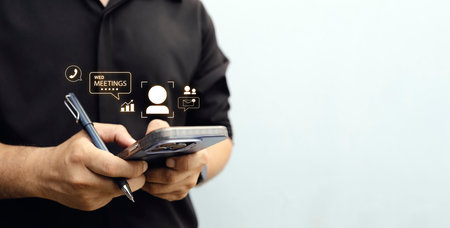 Man using smartphone with virtual icons, representing remote work, digital meetings, and online...