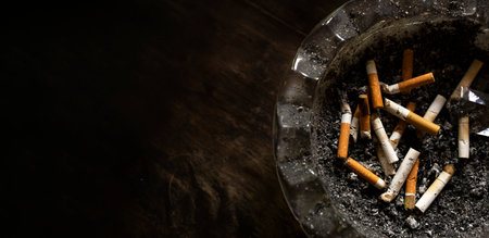 Close-up image of used cigarette butts symbolizing addiction, lung damage, toxic smoke, health warning, and need to quit smokingの写真素材