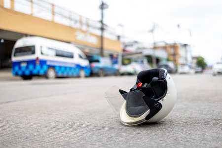 Protective motorcycle helmet lying on urban street symbolizing traffic safety, prevention, and road awareness for riders.の写真素材