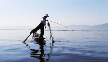 INLE LAKE, MYANMAR â JANUARY 21, 2017: Burmese Fisherman on a boat catching fish in the morning at Inle Lake, Myanmar.のeditorial素材